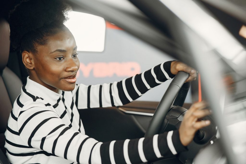 Woman smiling confidently while driving, demonstrating Pass Plus safe driving skills.